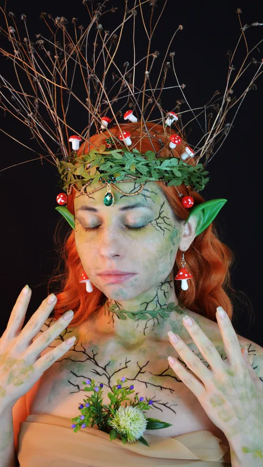 Woman in forest elf makeup with pointed ears and a crown of branches